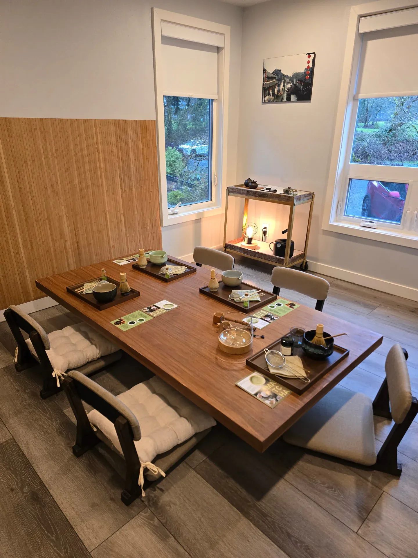 A long table set for a tea ritual with floor cushions