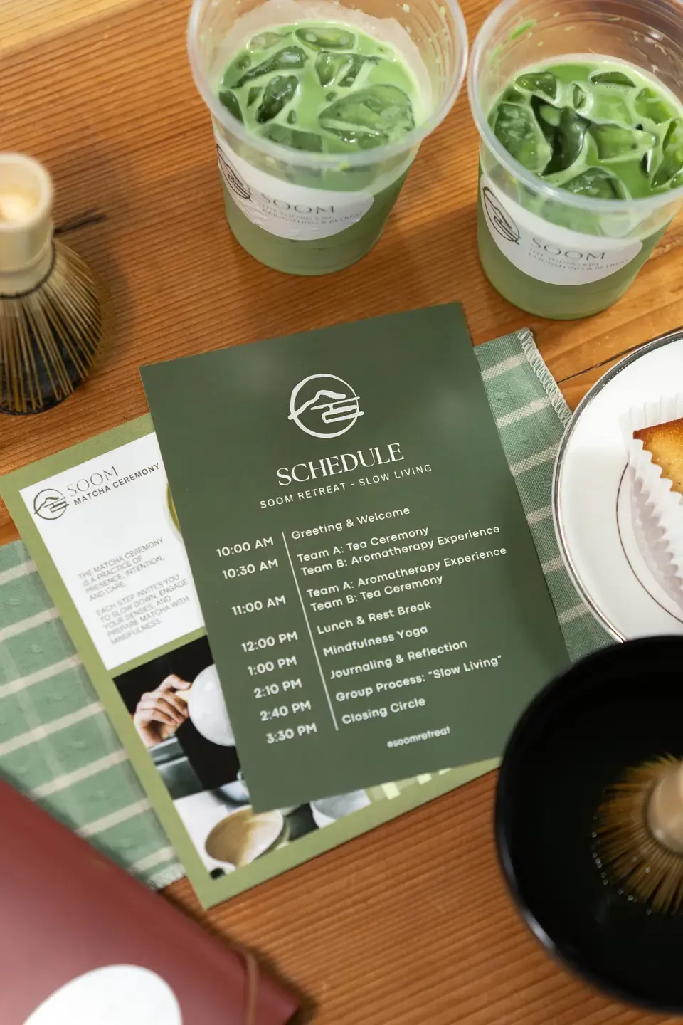 Two cups of green matcha latte on a wooden table, along with a schedule for a Soom retreat featuring activities like tea ceremony, aromatherapy, mindfulness yoga, journaling, group process, and closing circle.